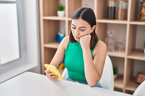Νεαρή Ισπανόφωνη Γυναίκα Που Ανησυχεί Χρησιμοποιώντας Smartphone Κάθεται Στο Γραφείο — Φωτογραφία Αρχείου