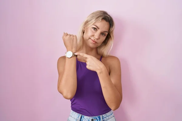 Young Blonde Woman Standing Pink Background Hurry Pointing Watch Time — Foto de Stock