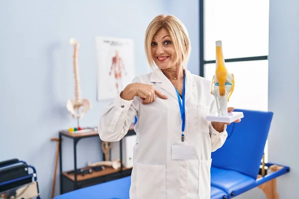 Middelbare Leeftijd Blonde Traumatoloog Vrouw Met Anatomisch Model Van Kniegewricht — Stockfoto