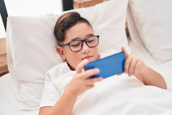 Чарівний Іспаномовний Хлопчик Дивиться Відео Смартфон Лежачи Ліжку Спальні — стокове фото