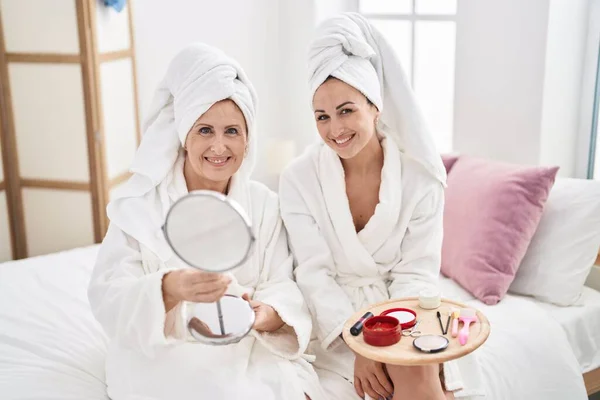 Mother Daughter Wearing Bathrobe Applying Skin Lotion Treatment Bedroom —  Fotos de Stock
