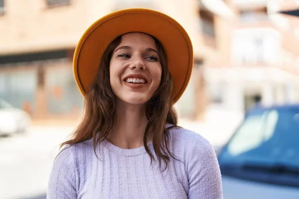 여자가 자랑스럽게 거리에서 모자를 웃는다 — 스톡 사진