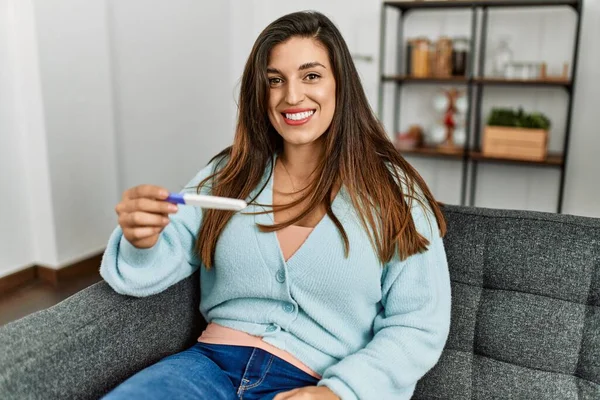 Hamilelik Testi Sonuçlarına Bakan Genç Bir Kadın Evdeki Kanepede Oturuyor — Stok fotoğraf