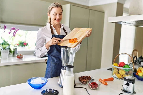 Young Blonde Woman Smiling Confident Pouring Carrot Blender Kitchen — 图库照片