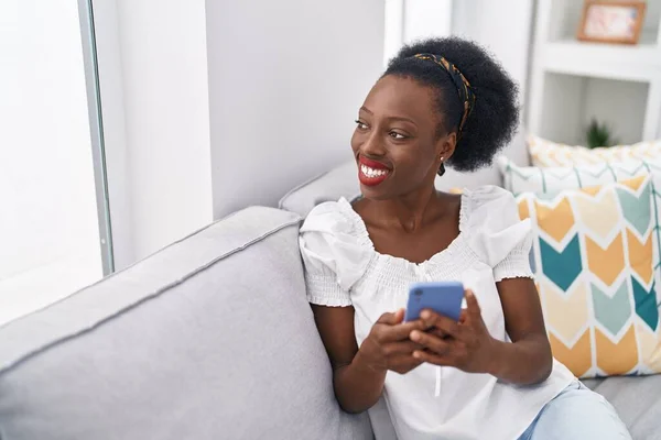 Mujer Afroamericana Usando Teléfono Inteligente Sentado Sofá Casa — Foto de Stock