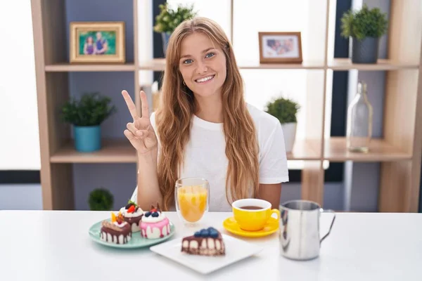 Jonge Blanke Vrouw Eten Gebak Voor Ontbijt Tonen Wijzen Met — Stockfoto