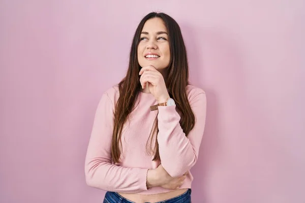 Young Brunette Woman Standing Pink Background Hand Chin Thinking Question — 图库照片