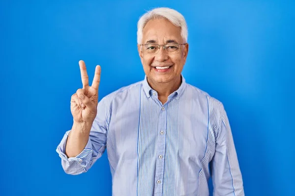 西班牙裔老人戴着眼镜 用第二指尖 脸上带着自信和快乐的笑容 — 图库照片