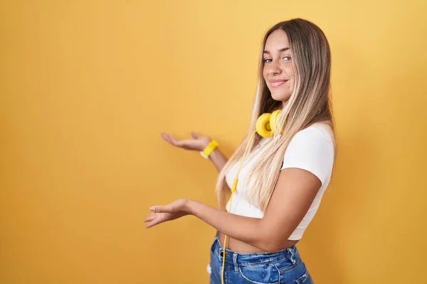 Mladá Blondýna Žena Stojící Nad Žlutým Pozadím Nosí Sluchátka Zvoucí — Stock fotografie