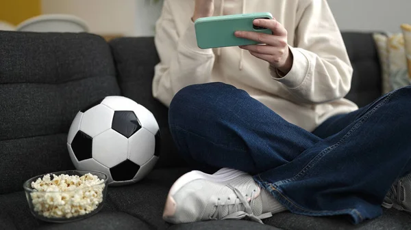 Ung Blond Kvinna Tittar Fotbollsmatch Smartphone Sitter Soffan Hemma — Stockfoto