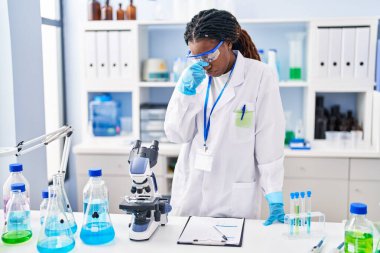 African american woman scientist stressed standing at laboratory