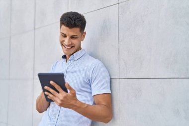 Sokakta dokunmatik ped kullanan, kendine güvenen İspanyol genç adam.