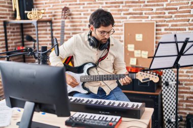 Genç İspanyol müzisyen müzik stüdyosunda elektro gitar çalıyor.