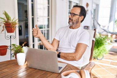 Çağrı merkezi kulaklığı takan orta yaşlı bir adam mutlu bir gülümseme ve el kaldırarak zaferi kutluyor. 