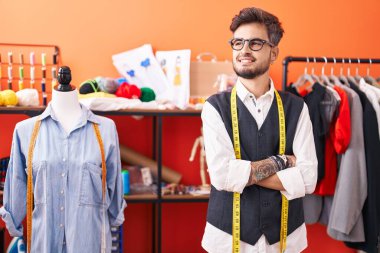 Genç İspanyol terzi gülümsüyor. Kollarını kavuşturup atölyeye bakıyor.