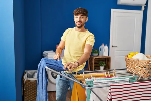 Young Arab Man Smiling Confident Hanging Clothes Clothesline Laundry Room — Stockfoto