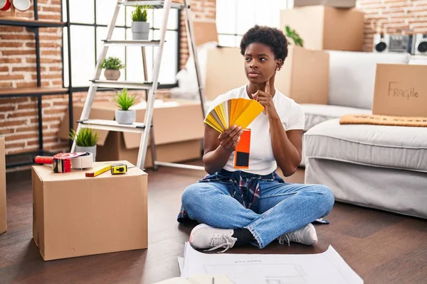African American Woman Choosing Paint Color Sitting Floor New Home — ストック写真