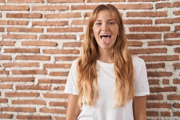 Mujer Joven Caucásica Pie Sobre Pared Ladrillos Sacando Lengua Feliz —  Fotos de Stock