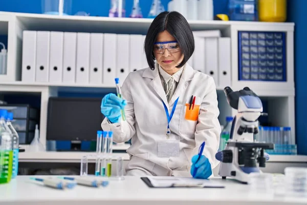 Young Chinese Woman Scientist Holding Test Tube Write Report Document — Stockfoto
