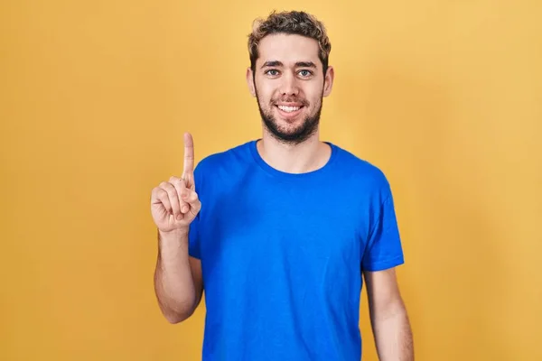Hispanic Man Beard Standing Yellow Background Showing Pointing Finger Number — Stockfoto