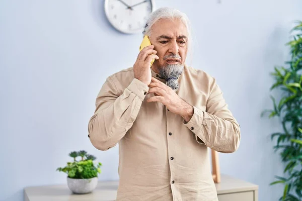Middle Age Grey Haired Man Talking Smartphone Worried Expression Home — Foto Stock