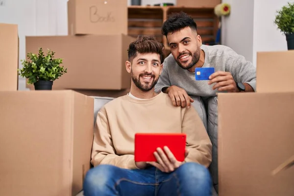 Young Couple Using Touchpad Credit Card Sitting Sofa New Home — Foto de Stock
