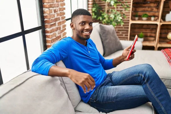 Young African American Man Using Touchpad Sitting Sofa Home — Stock fotografie