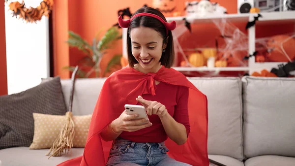Young Beautiful Hispanic Woman Wearing Devil Costume Using Smartphone Home — Fotografia de Stock