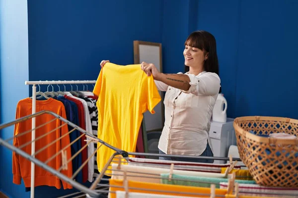 Young Beautiful Hispanic Woman Smiling Confident Holding Shirt Laundry Room —  Fotos de Stock