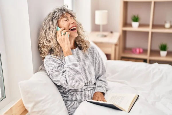 Orta Yaşlı Bir Kadın Yatak Odasında Oturmuş Akıllı Telefondan Konuşuyor — Stok fotoğraf
