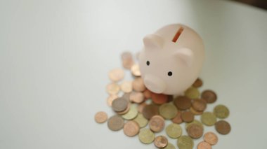 Güzel İspanyol kadın evde domuz kumbarasıyla masada oturuyor.