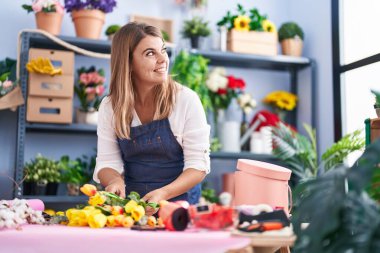 Young woman florist make bouquet of flowers at florist