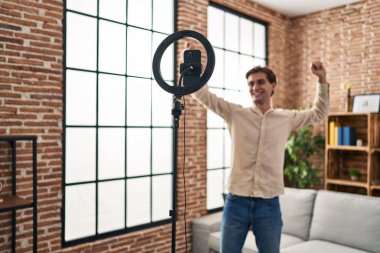 Young caucasian man recording video dancing at home