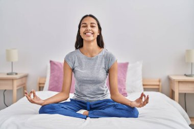 Genç Afrikalı Amerikalı kadın yoga egzersizi yapıyor. Yatak odasında oturuyor.