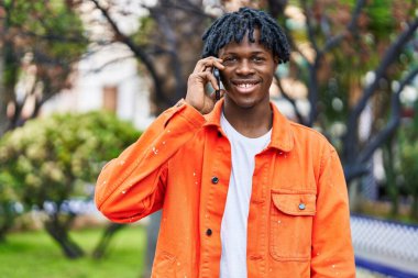 African american man smiling confident talking on the smartphone at park