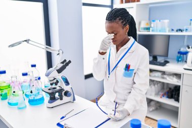 African american woman scientist stressed working at laboratory