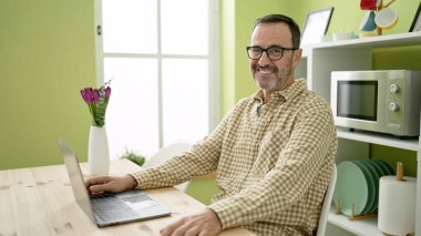 Çağrı merkezi kulaklığı takan orta yaşlı bir adam mutlu bir gülümseme ve el kaldırarak zaferi kutluyor. 