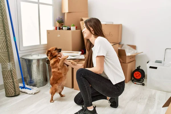 Young Hispanic Woman Smiling Confident Playing Dog New Home — ストック写真