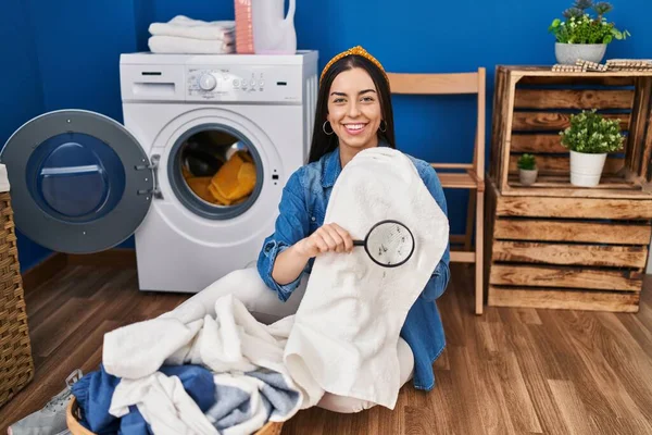 Hispanic Woman Holding Magnifying Glass Looking Stain Clothes Smiling Happy — Stok fotoğraf