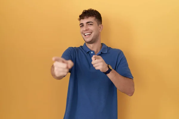 Mladý Hispánec Stojící Nad Žlutým Pozadím Ukazuje Prsty Kameru Šťastnou — Stock fotografie