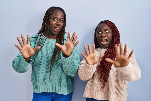 Two African Woman Standing Blue Background Afraid Terrified Fear Expression — Stock Photo, Image