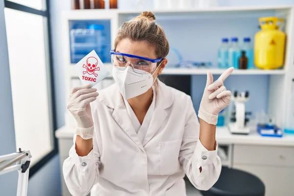Νεαρή Γυναίκα Που Εργάζεται Στο Εργαστήριο Επιστήμονας Κρατώντας Τοξικό Πανό — Φωτογραφία Αρχείου