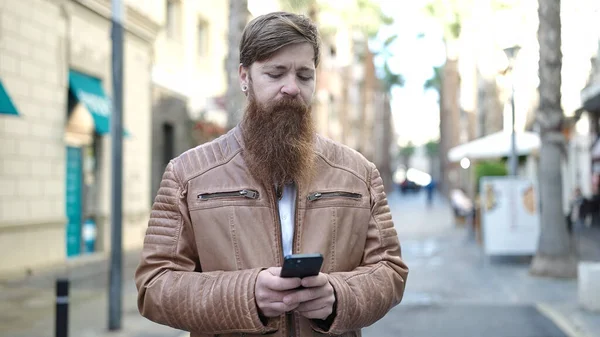 Jonge Roodharige Man Met Behulp Van Smartphone Met Ontspannen Uitdrukking — Stockfoto