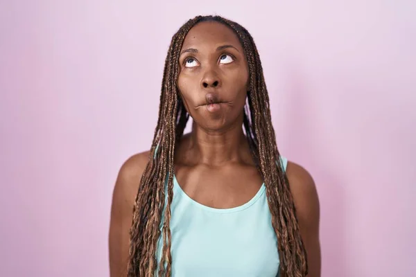 非洲裔美国妇女站在粉红的背景上 用嘴唇 疯狂和滑稽的姿势做鱼脸 有趣的表达方式 — 图库照片