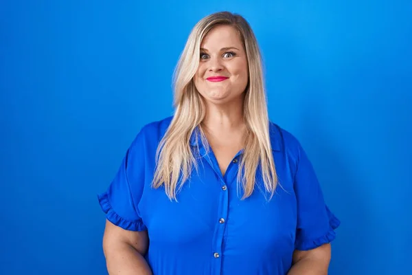 Stock image Caucasian plus size woman standing over blue background smiling looking to the side and staring away thinking. 