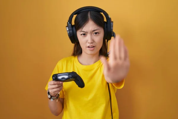 中国年轻女子玩电子游戏时握住控制器 用手心 愤怒和沮丧的表情做停止动作 — 图库照片