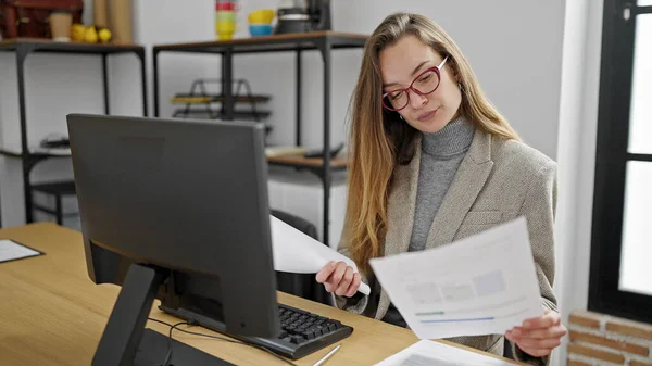 若い白人女性のビジネス労働者はオフィスでコンピュータ読書文書を使用して — ストック写真