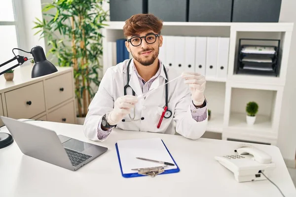 Young Arab Man Wearing Doctor Uniform Holding Antigen Test Clinic — Stockfoto