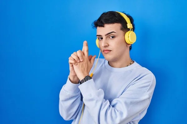 Δυαδικό Άτομο Που Ακούει Μουσική Χρησιμοποιώντας Ακουστικά Κρατώντας Συμβολικό Όπλο — Φωτογραφία Αρχείου