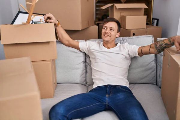 Young Man Smiling Confident Sitting Sofa New Home — Stockfoto